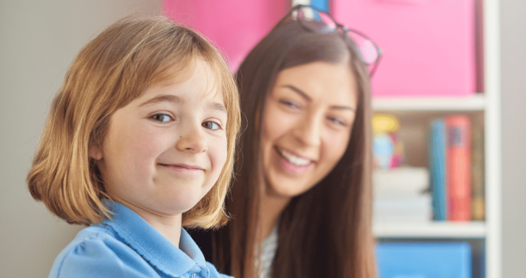 Girl in school uniform completing Reception baseline assessment with teacher