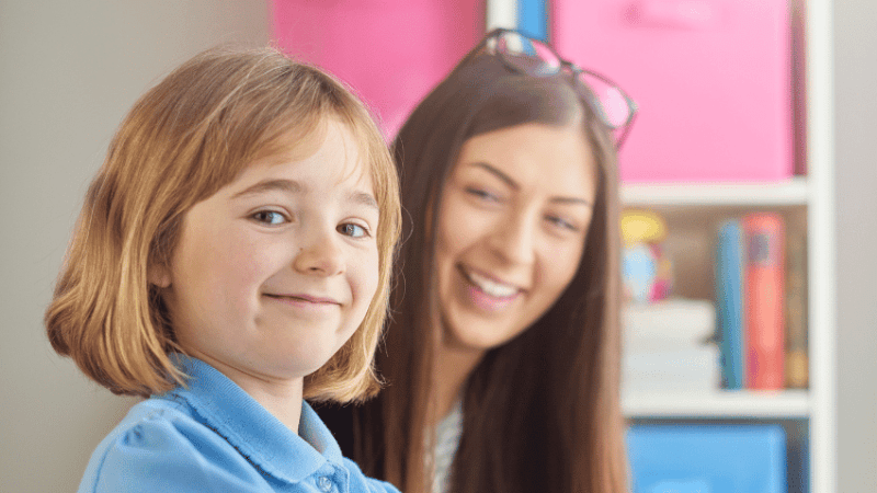 Girl in school uniform completing Reception baseline assessment with teacher