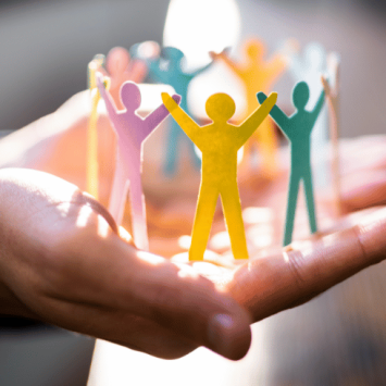 Circle of paper figures standing on businessperson's outstretched palms, representing middle leadership in schools