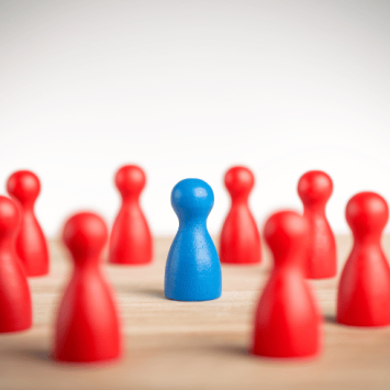 Group of red game pieces, surrounding a blue game piece, representing collective punishment
