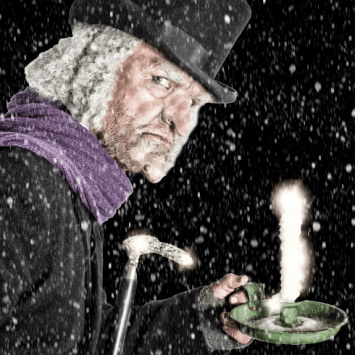 Scrooge in the snow with a candle