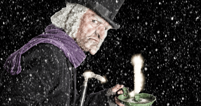 Scrooge in the snow with a candle