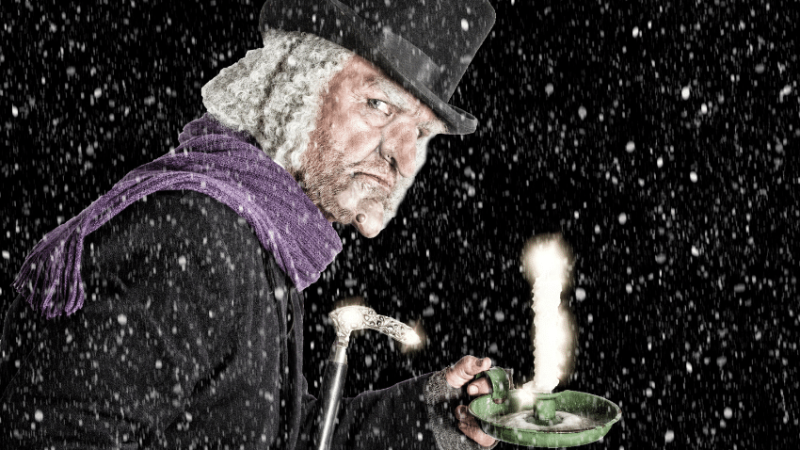 Scrooge in the snow with a candle