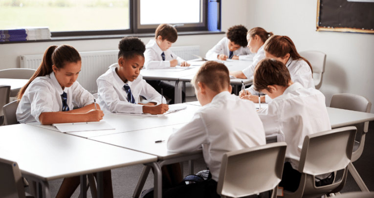 Students writing poetry comparison essays in classroom