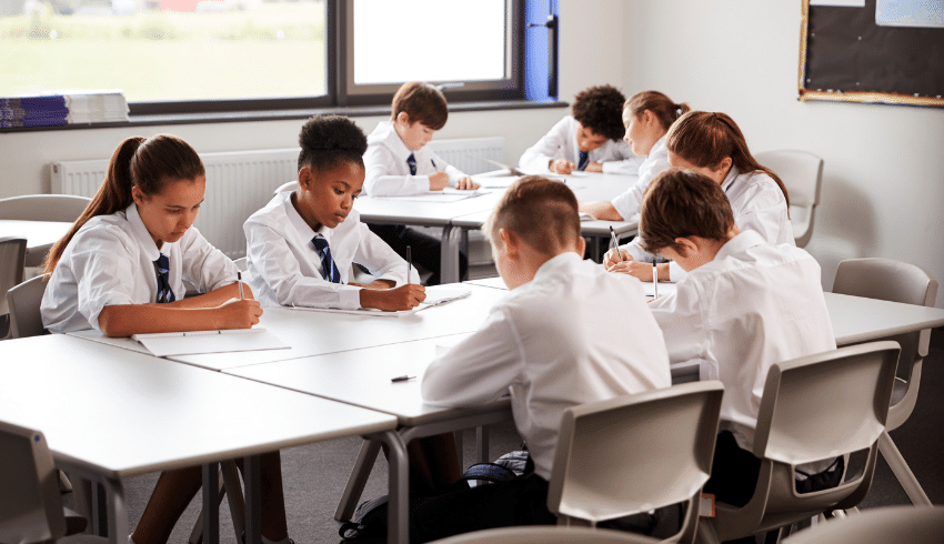 Students writing poetry comparison essays in classroom
