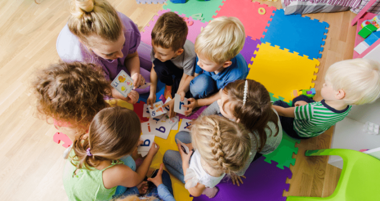 Children in a circle with teacher, representing behaviour management in early years