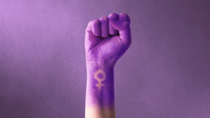 Fist painted purple, with feminine symbol, representing International Women's Day