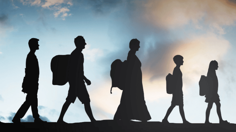 Silhouetted figures walking in a line, to represent Refugee Week