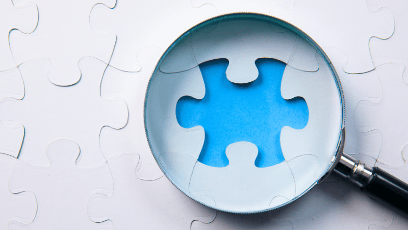 Magnifying glass on missing puzzle piece, epresenting Intent, Implementation, Impact element of Ofsted inspections