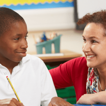 Schoolboy and teacher in creative writing lesson