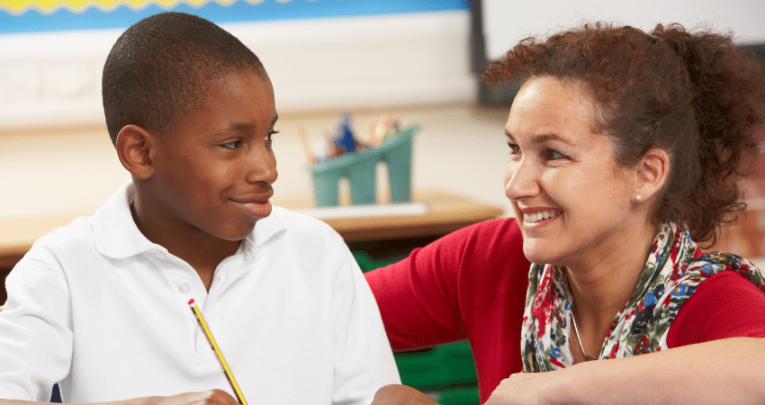 Schoolboy and teacher in creative writing lesson