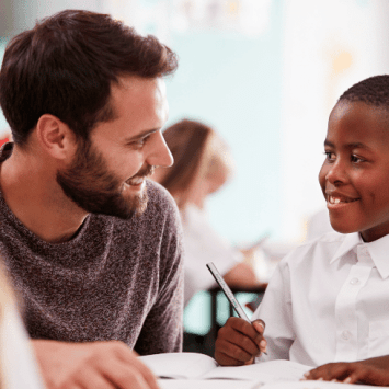 Schoolboy with Developmental Language Disorder smiling at teacher