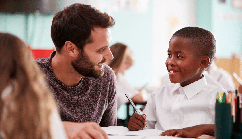 Schoolboy with Developmental Language Disorder smiling at teacher
