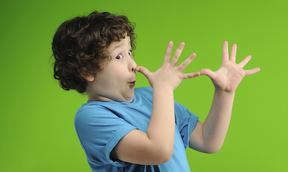 Young boy in blue school uniform pulls funny face