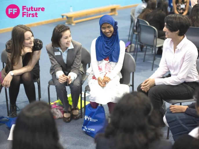 Students and alumni sitting on chairs in circle