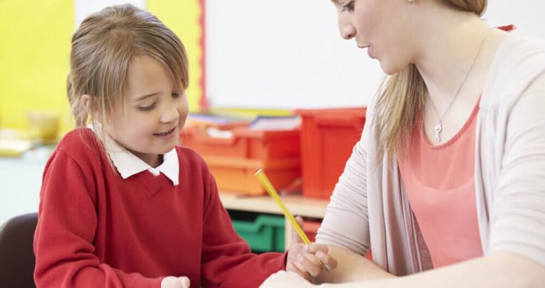Child and teacher in classroom doing SPaG