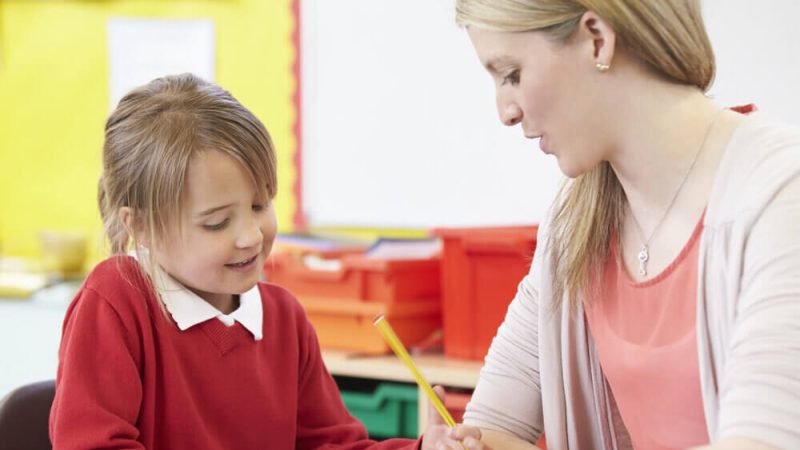 Child and teacher in classroom doing SPaG
