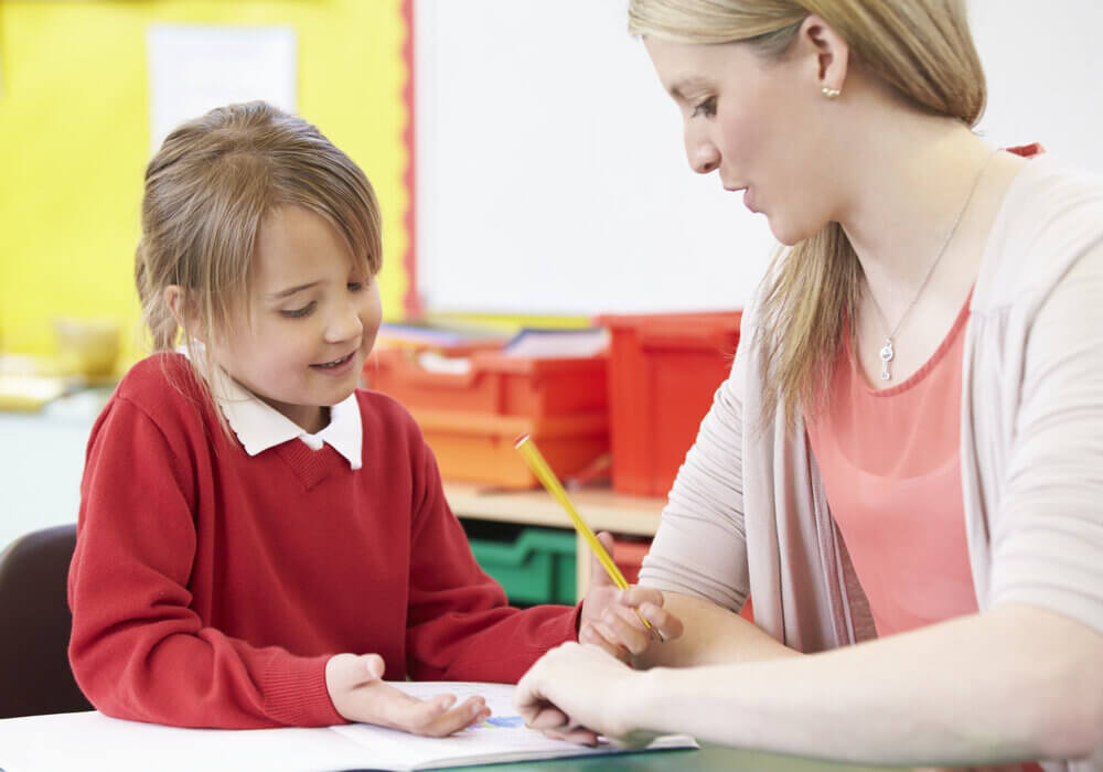 Child and teacher in classroom doing SPaG