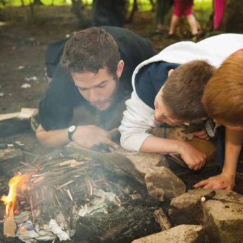 Kids lighting a fire on a residential trip for schools