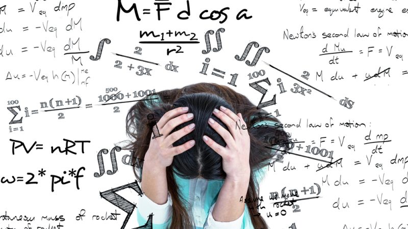 Student with head in hands, surrounded by maths symbols, representing maths anxiety