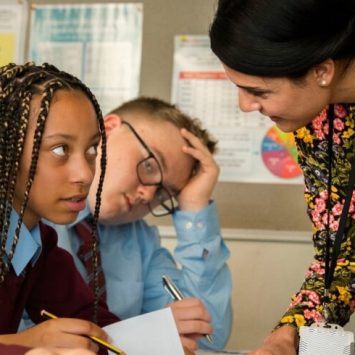 close up on female teacher assisting a teenage girl in a classroom