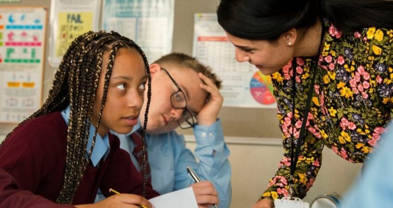 close up on female teacher assisting a teenage girl in a classroom