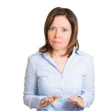 Female teacher gestures for calm in an effort to manage a student's behaviour