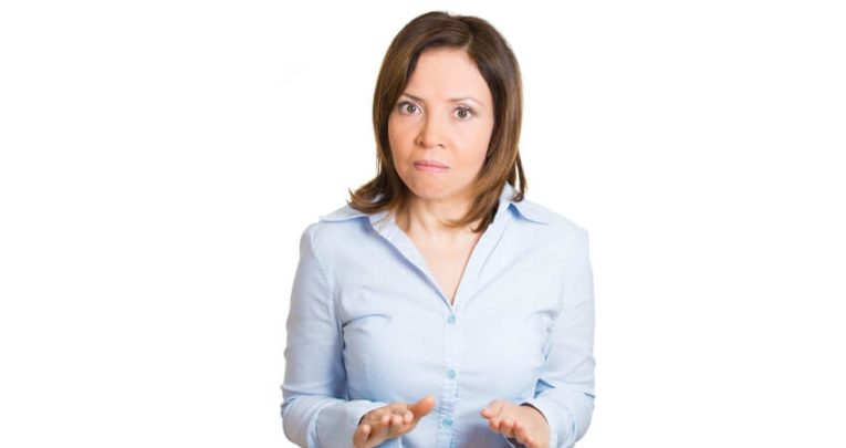 Female teacher gestures for calm in an effort to manage a student's behaviour