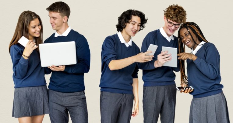 group of school students using laptops and tablets