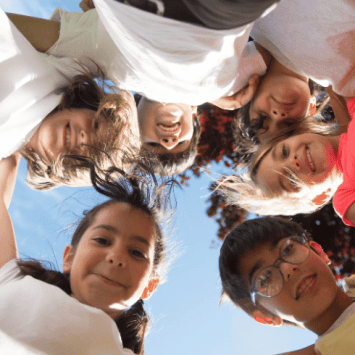 Children in a circle looking happy during Anti Bulllying Week