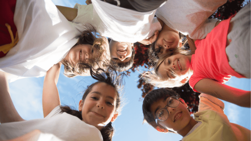 Children in a circle looking happy during Anti Bulllying Week