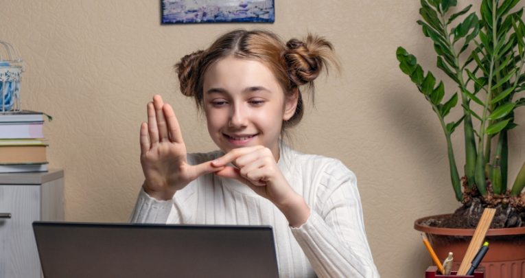 Photo of deaf teenage girl signing during a video call