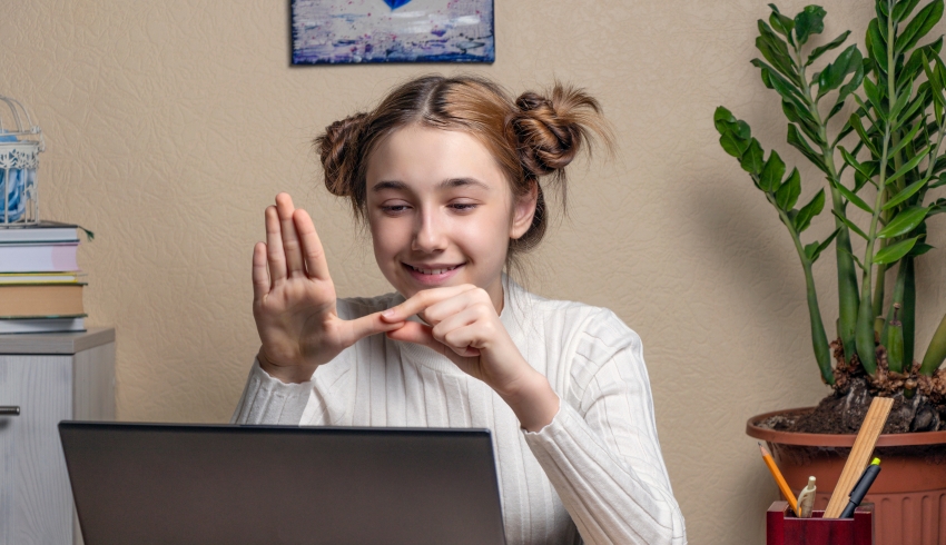 Photo of deaf teenage girl signing during a video call