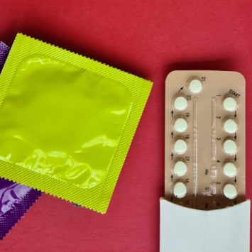 Close up on prophylactics in packets and a pack of contraceptive pills
