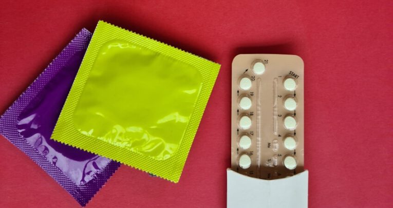 Close up on prophylactics in packets and a pack of contraceptive pills