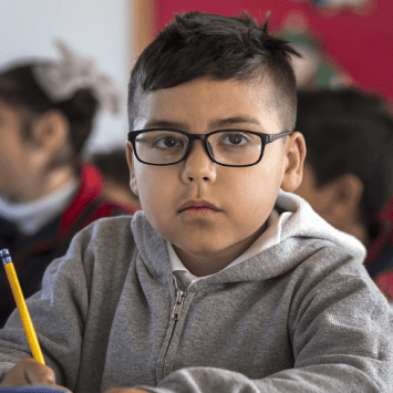 Schoolboy holding pencil, representing inclusion in schools