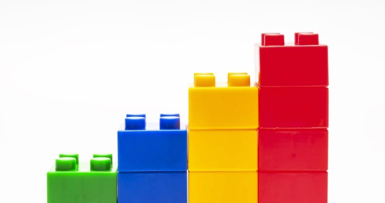 four stacks of colourful children's building blocks, ascending in height