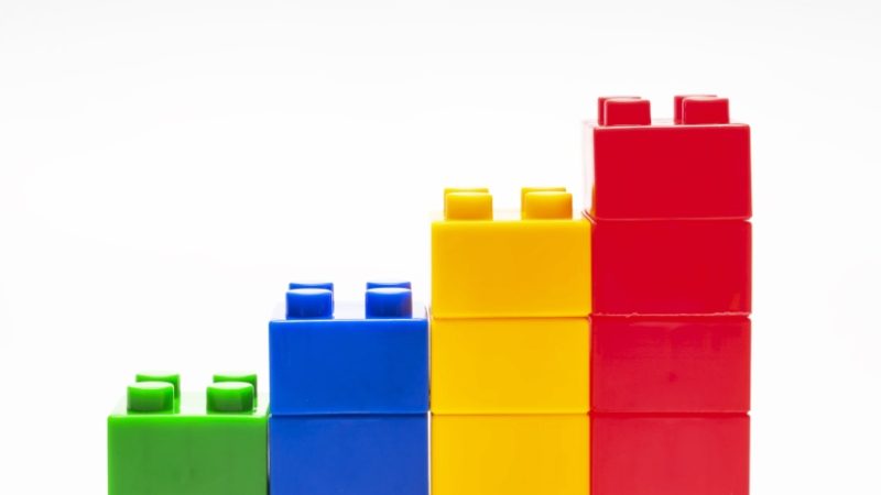 four stacks of colourful children's building blocks, ascending in height