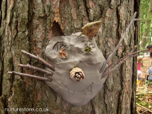 Reggio Emilia approach activity idea involving making clay faces pushed into tree trunks