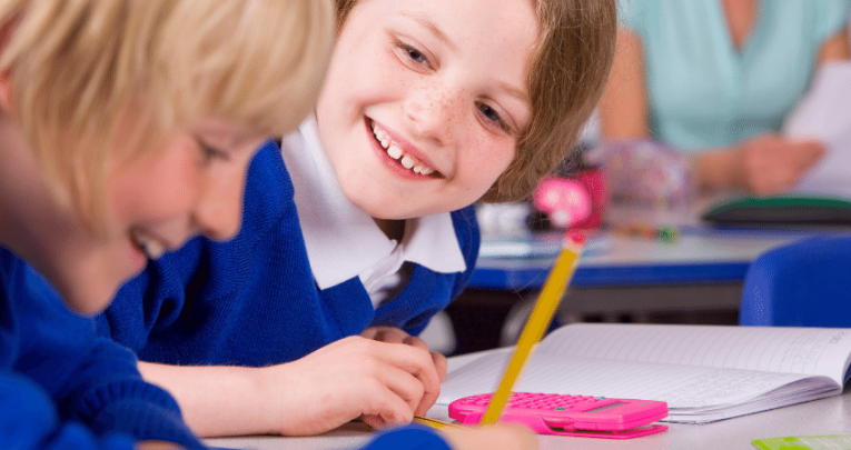 Children laughing as they work together in the classroom