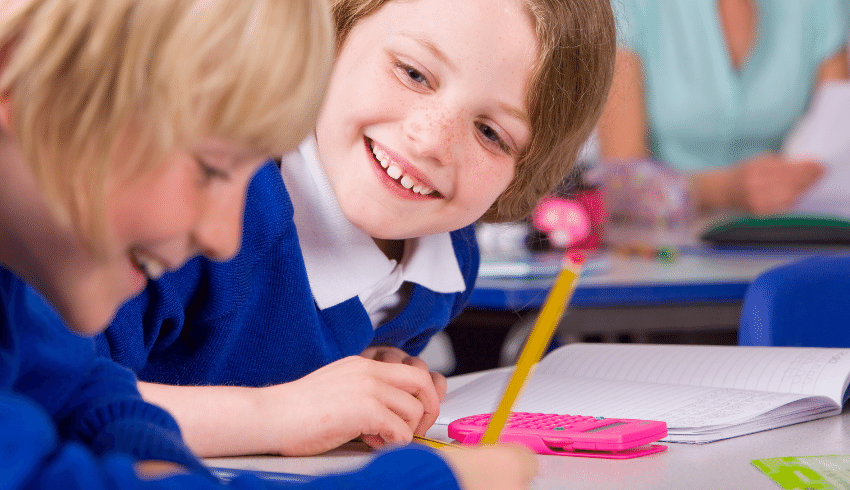 Children laughing as they work together in the classroom