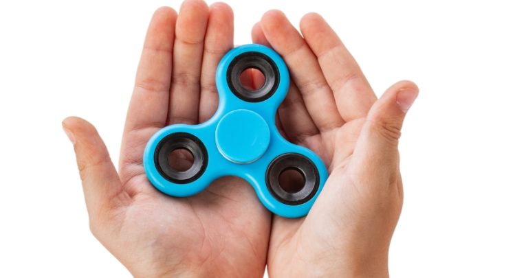 close-up photograph of hands holding a fidget spinner