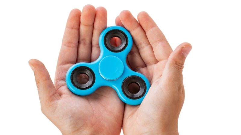 close-up photograph of hands holding a fidget spinner