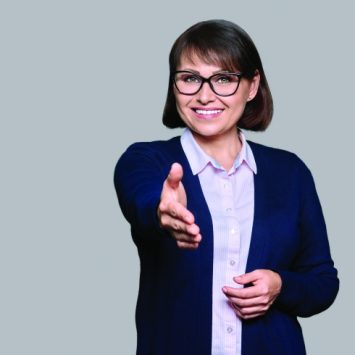 photo of a female teacher extending a hand of welcome
