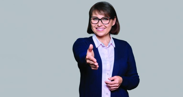 photo of a female teacher extending a hand of welcome