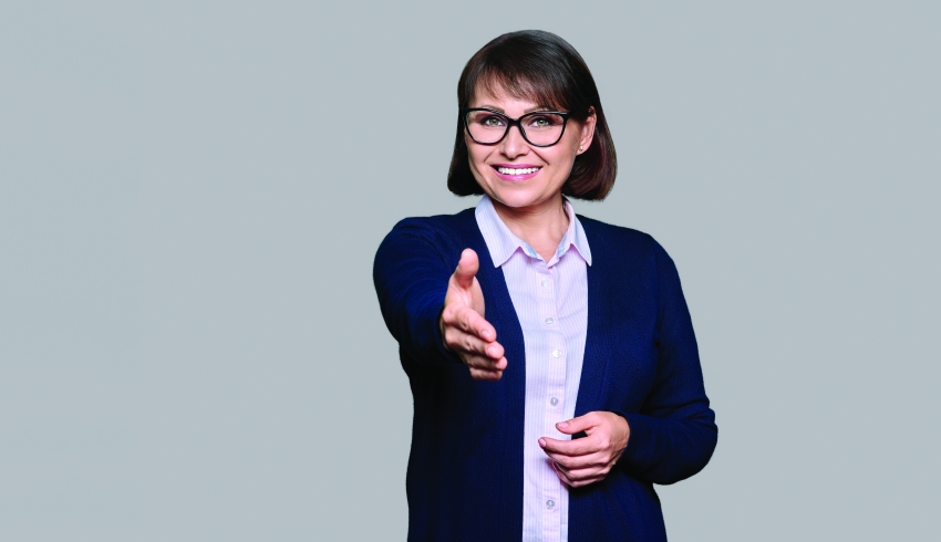 photo of a female teacher extending a hand of welcome