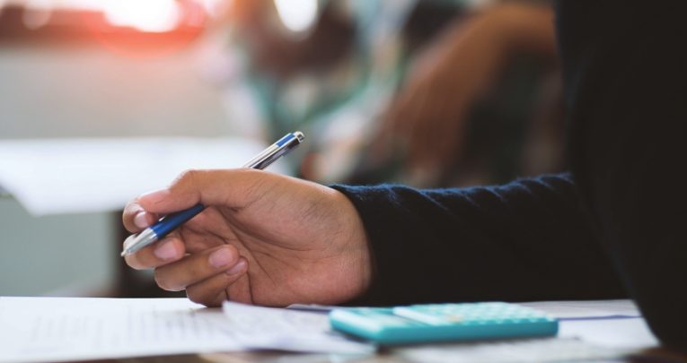 close-up on a school student adding surds in a maths task in class