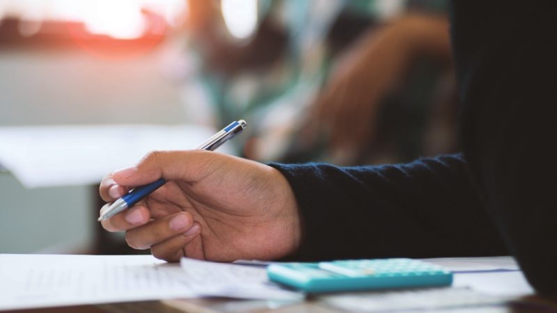 close-up on a school student adding surds in a maths task in class