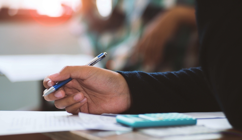 close-up on a school student adding surds in a maths task in class