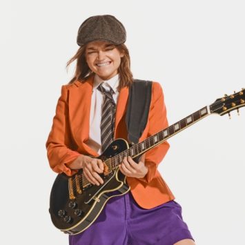 Teenage girl posing dramatically with an electric guitar